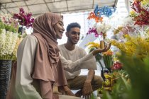 Молода мусульманська пара купує квіти . — стокове фото