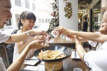 Feliz asiático família comer macarrão juntos no rua café — Fotografia de Stock