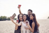 Attractive young asian friends taking selfie at beach — Stock Photo