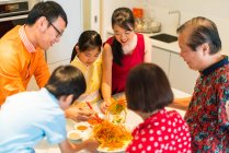 Щаслива азіатська сім'я їсть разом за столом — стокове фото