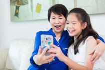 Nonna e bambino prendere un selfie a casa — Foto stock