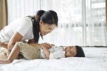 Asiatische Mutter bonding mit Ihr Sohn auf die Bett — Stockfoto