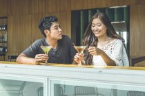 Couple having easy talk and drinks at Sentosa beach club — Stock Photo
