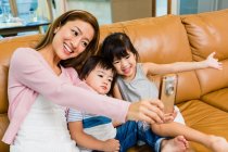 Mãe e filhos tomando uma selfie em casa — Fotografia de Stock