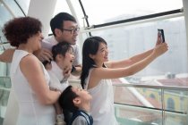 Una famiglia asiatica di tre generazioni si fa un selfie in un centro commerciale — Foto stock