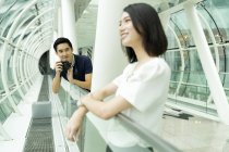 Jeune attrayant asiatique couple avec caméra dans le centre commercial — Photo de stock