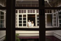 Jovem atraente asiático casal juntos olhando para fora da janela — Fotografia de Stock
