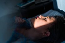 Молода доросла азіатська жінка розслабляється в ліжку — стокове фото