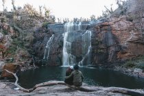Молодая путешествующая пара наслаждается водопадом — стоковое фото