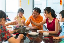 Счастливая азиатская семья едят вместе за столом — стоковое фото