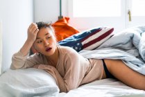Китаянка на кровати выглядит сексуально — стоковое фото