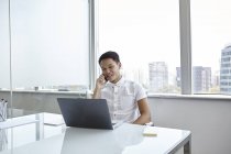 Young asian business man at work in modern office — Stock Photo