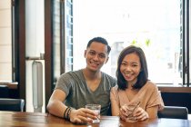 Young attractive asian couple having date in cafe — Stock Photo