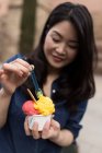Chinês mulher de cabelo comprido comer sorvete nas ruas de Barcelona, Espanha — Fotografia de Stock