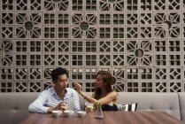 Jeune attrayant asiatique couple ensemble assis dans café — Photo de stock