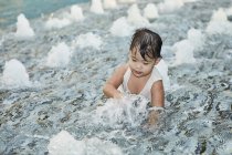 Young little asian toddler girl playing in waves — Stock Photo