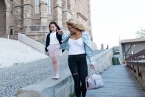 Щаслива молода мати з дочкою, що йде містом — стокове фото
