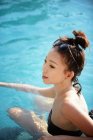 Gros plan vue de heureux belle asiatique femme natation dans piscine — Photo de stock