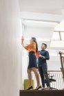 Young asian couple celebrating Chinese New Year together and decorating home — Stock Photo