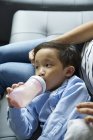 Молодий хлопчик п'є молоко з пляшки — стокове фото