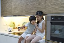 Feliz joven asiático familia juntos comer en cocina - foto de stock