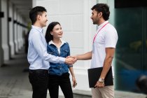 Male salesperson speaking to couple on the street. — Stock Photo