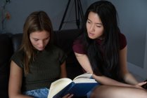 Chinese woman looking a book with her friend. — Stock Photo