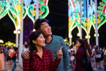 Young asian couple spending time together in city while celebrating christmas — Stock Photo