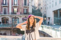 Joven atractivo asiático mujer posando en ciudad calle - foto de stock