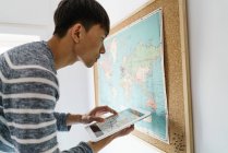 Joven adulto asiático hombre usando digital tablet en casa - foto de stock