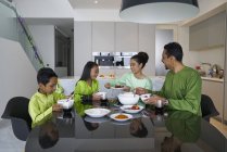 Jeune asiatique famille célébrant hari raya ensemble à la maison — Photo de stock