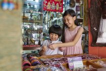 Asian brother and sister at street market — Stock Photo