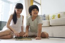 Felice giovane famiglia asiatica insieme, bambini che giocano scarabeo a casa — Foto stock