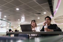 Succès entreprise asiatique couple ensemble travailler avec ordinateur portable à l'aéroport — Photo de stock