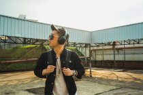 Jovem asiático elegante homem em fones de ouvido — Fotografia de Stock