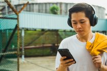 Jeune asiatique élégant homme en utilisant smartphone — Photo de stock