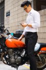 Giovane asiatico uomo d'affari in città utilizzando cellulare — Foto stock