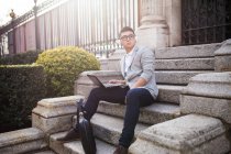 Hombre de negocios chino que trabaja al aire libre utilizando una tableta, España - foto de stock