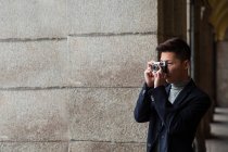 Jovem chinês Casual tirando fotos com uma câmera fotográfica vintage em Madrid, Espanha — Fotografia de Stock