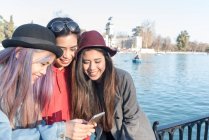 Frauen schauen auf ihr Smartphone im pensionro park madrid, spanien — Stockfoto