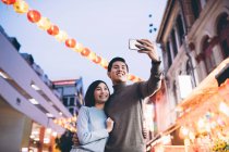 Glückliches asiatisches Paar feiert chinesisches Neujahr in der Stadt und macht Selfie — Stockfoto