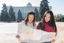 Mujeres asiáticas haciendo turismo en Madrid con un mapa, España - foto de stock