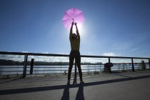 Mujer china con su paraguas rosa en el puente - foto de stock