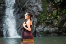 Attrayant asiatique jeune femme relaxant près de cascade en Thaïlande — Photo de stock