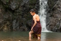 Attraente asiatico giovane donna rilassante vicino cascata in thailandia — Foto stock