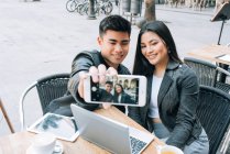Счастливая молодая азиатская туристическая пара делает селфи на смартфоне в Барселоне, Испания — стоковое фото