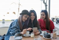 Tres mujeres jóvenes en un café en Madrid, España - foto de stock