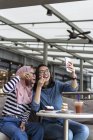 Deux femmes profitant de leur temps dans un café et prenant Selfie — Photo de stock