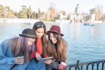 Jovens mulheres de cabelos longos navegando e olhando para seu tablet, Espanha — Fotografia de Stock