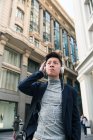 Jovem chinês casual ouvindo música na rua Gran Via, Madri, Espanha — Fotografia de Stock